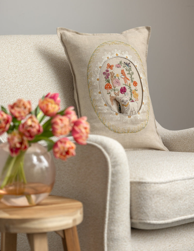 Coral & Tusk embroidered linen Sugar Egg Pocket Pillow in chair with fresh tulips on table