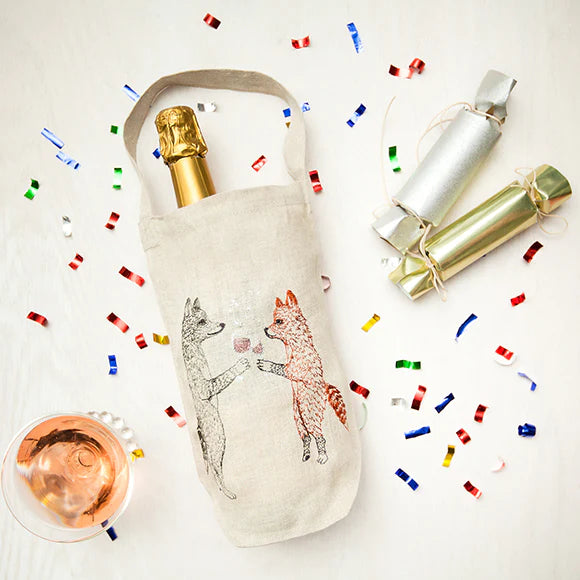 Overhead image of Coral and Tusk wine bag, glass and party confetti