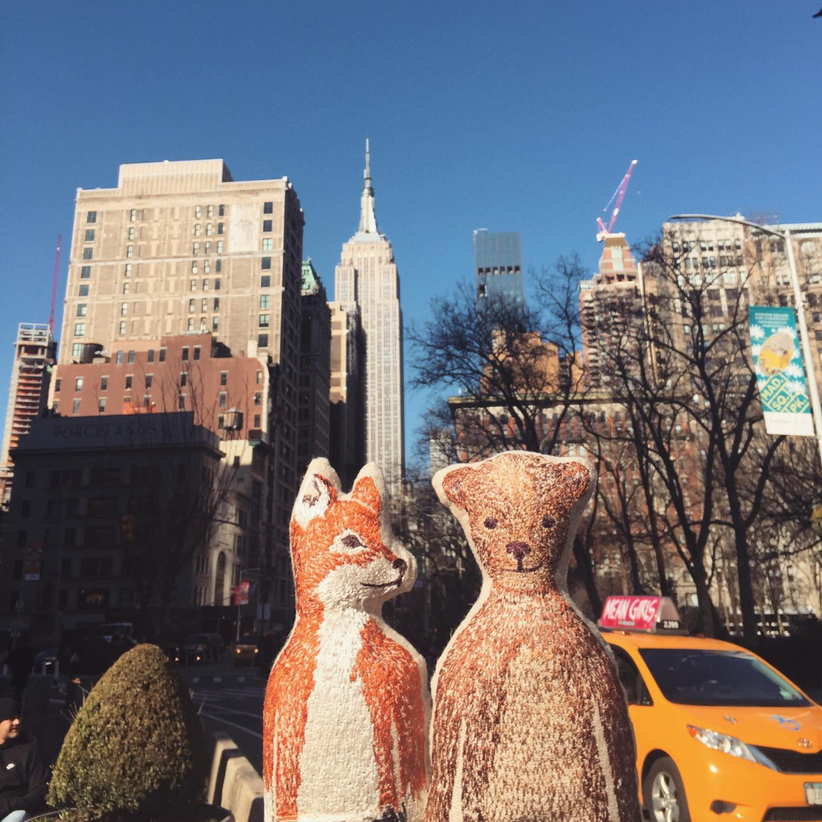 Coral & Tusk embroidered stuffed pocket dolls Fox and Bear take NYC in front of a yellow taxi and the Empire State Building