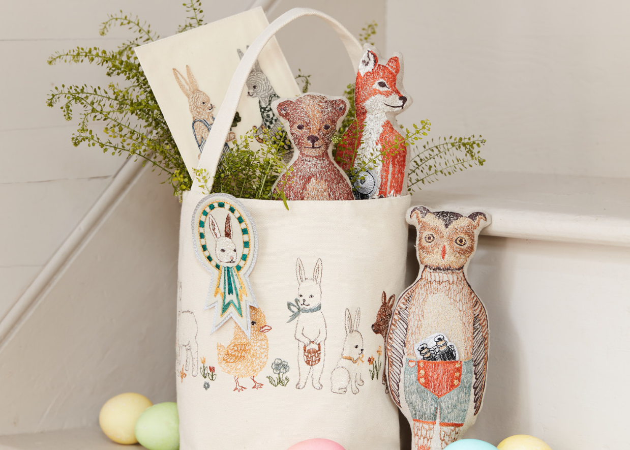 Coral & Tusk Spring Babies Bucket styled as an Easter basket with pocket dolls and card