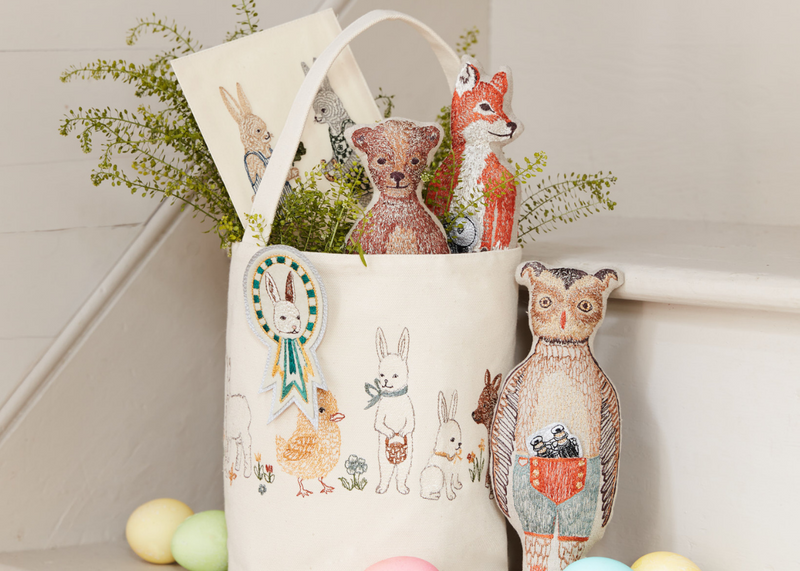 Coral & Tusk Spring Babies Bucket styled as an Easter basket with pocket dolls and card