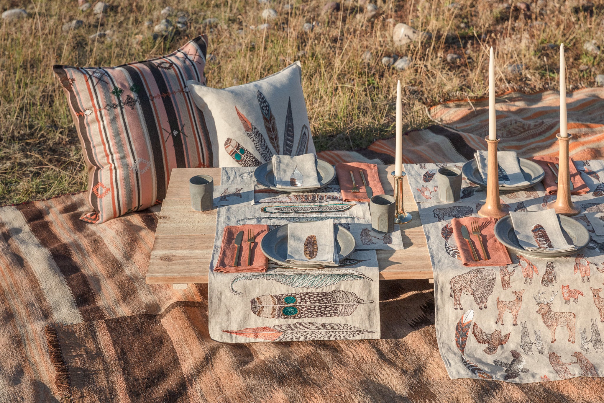 Elevated fall picnic spread with embroidered Coral & Tusk feather and animal table linens