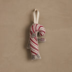 Coral & Tusk Candy Cane Cat embroidered linen stuffed ornament featuring gray Cat dressed in a red and white candy cane costume, holding a silver mug of cocoa topped with a marshmallow, facing to the right, with a white cotton loop at the top for hanging.