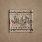 Coral & Tusk linen Jingle Bells Table Runner, folded, featuring detailed embroidery of a one-horse open sleigh full of woodland friends dashing through the forest, including Big Bear and Baby Bear, Fox wearing a green vest, Kitty in a blue dress, Rabbit with an orange scarf, and an owl sitting atop the sleigh, framed by a border of red ribbon, yellow-gold jingle bells, and pine boughs.