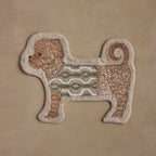 Coral & Tusk Dog in Sweater Pouch, dog-shaped and featuring an embroidered brown puppy wearing a sweater in white, sage, gray, and green, standing in profile with a zipper on the back.
