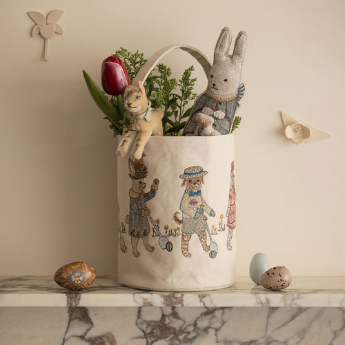 Coral & Tusk Egg Roll Easter bag with embroidered animal illustrations on a marble surface, styled with Easter Bunny Pocket Doll, toys, and eggs.